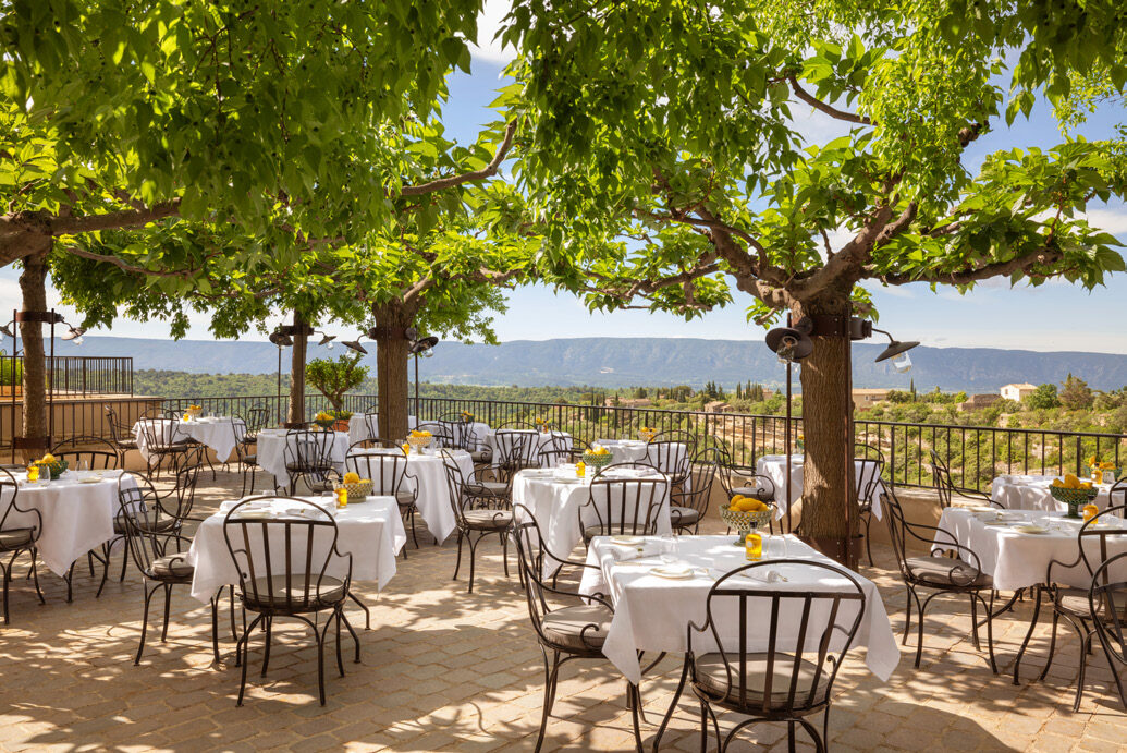 Outdoor terrace dining at Airelles La Bastide with panoramic views across the Luberon valley