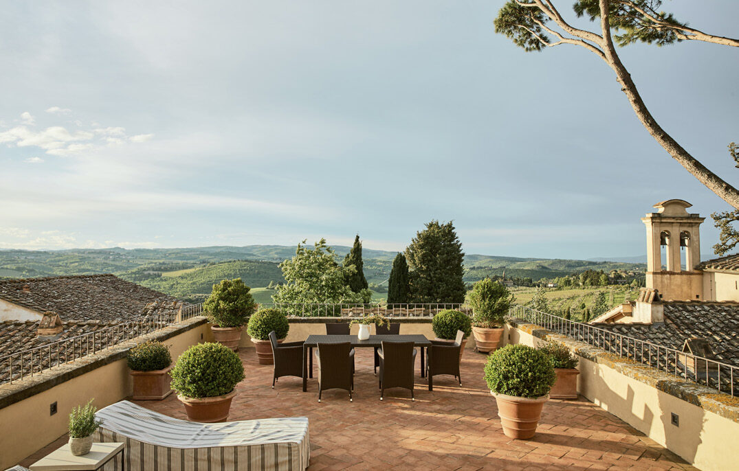 The terrace of COMO Castello Del Nero with sweeping views over the Tuscan hills