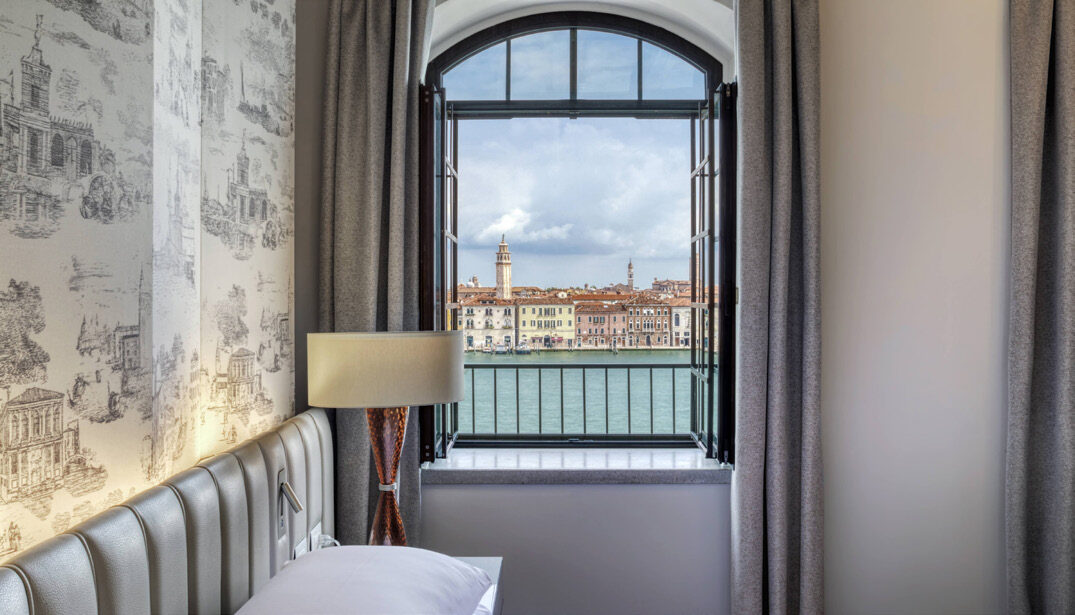 A guest room window at Hilton Molino Stucky Venice framing a view across the Venice waterway