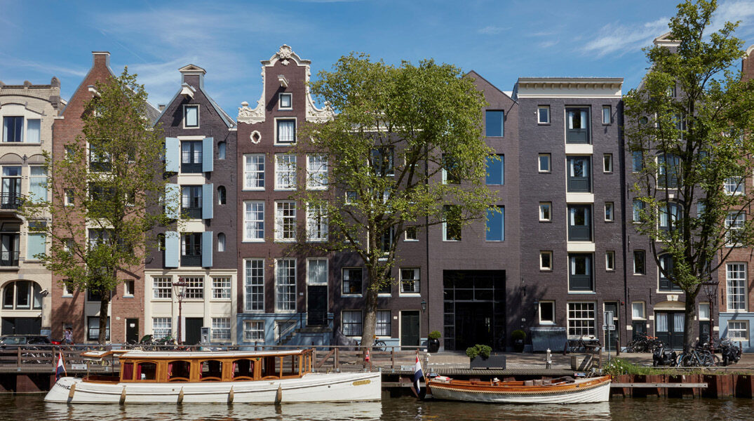 The iconic canal-side facade of Pulitzer Amsterdam spanning interconnected 17th- and 18th-century houses
