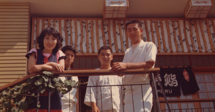 A young Nobu Matsuhisa with family and colleagues on a balcony outside a restaurant in Peru