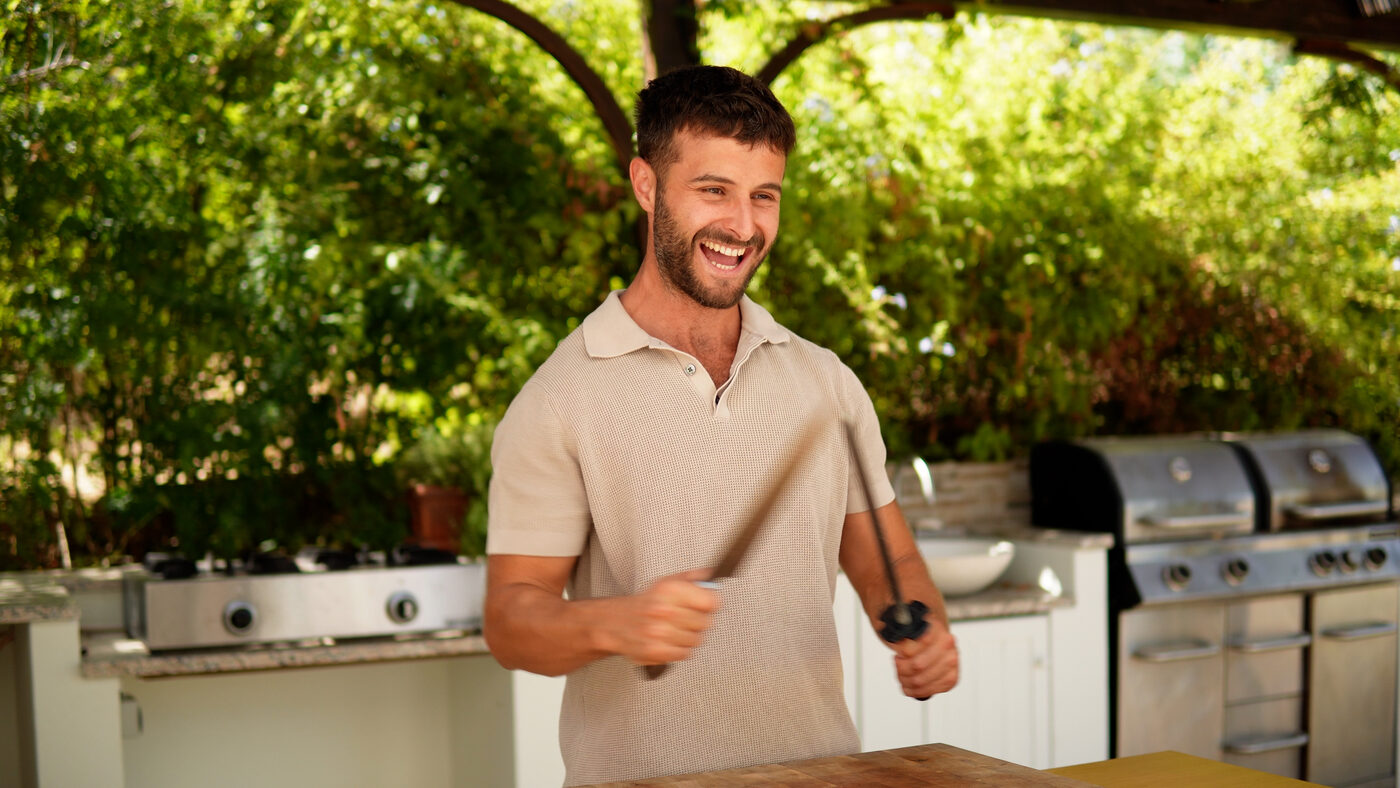 Adam Hollingsworth smiling in an outdoor kitchen
