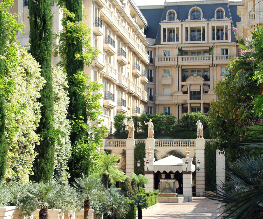 Hôtel Métropole Monte-Carlo exterior with lush gardens, cypresses and classical statues