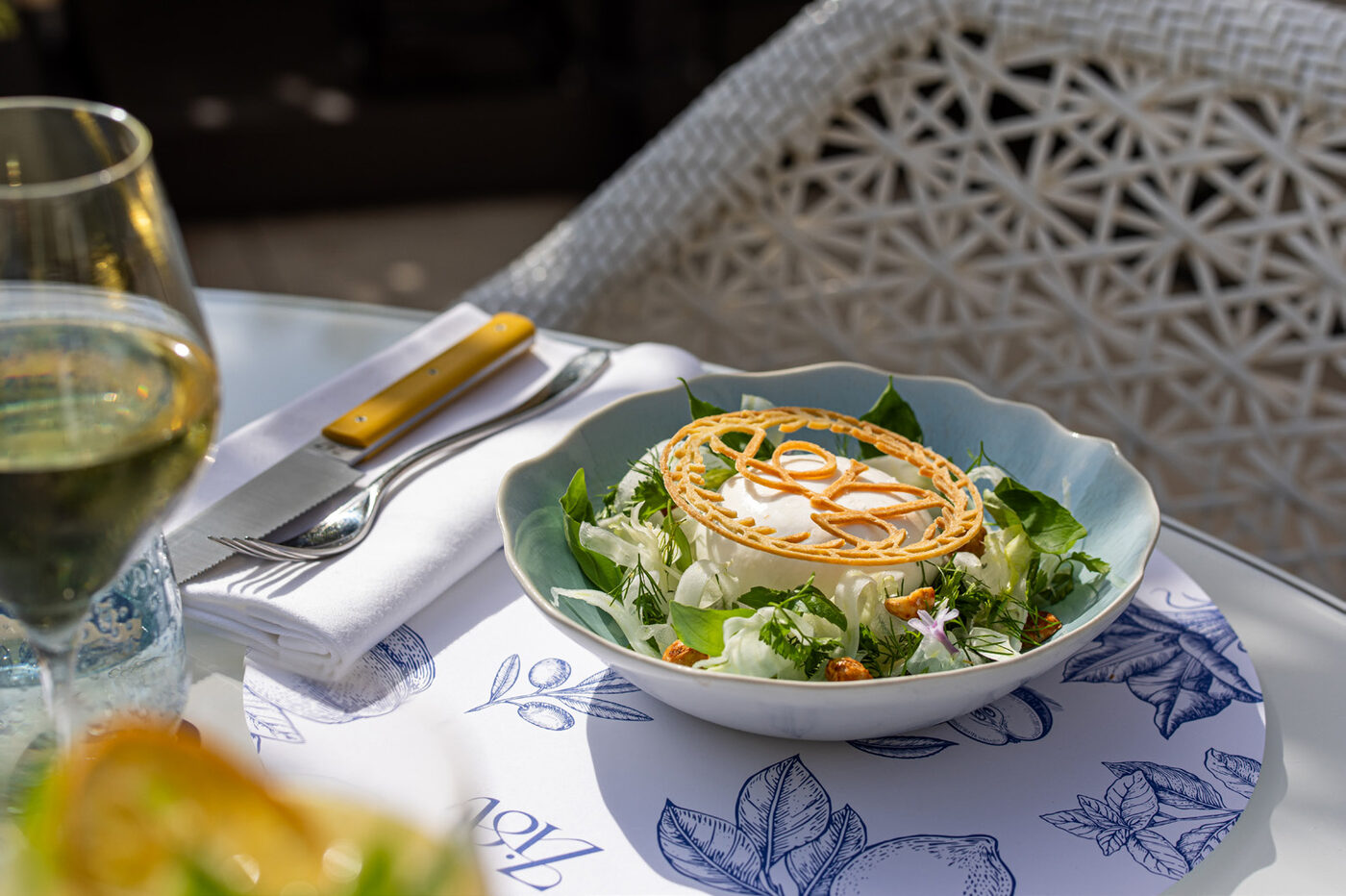 Elegant salad dish served at Zia restaurant, Monte Carlo, with a glass of white wine